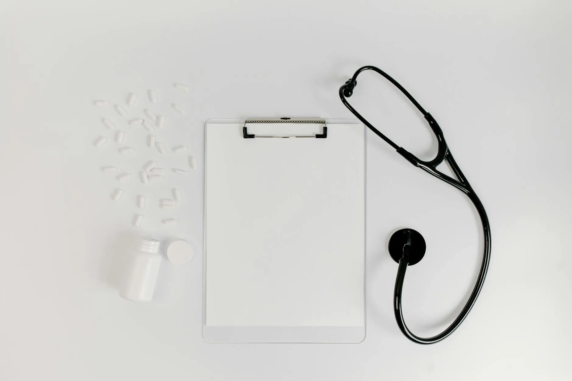 Pill bottles arranged with a stethoscope on a desk, representing prescription drug coverage