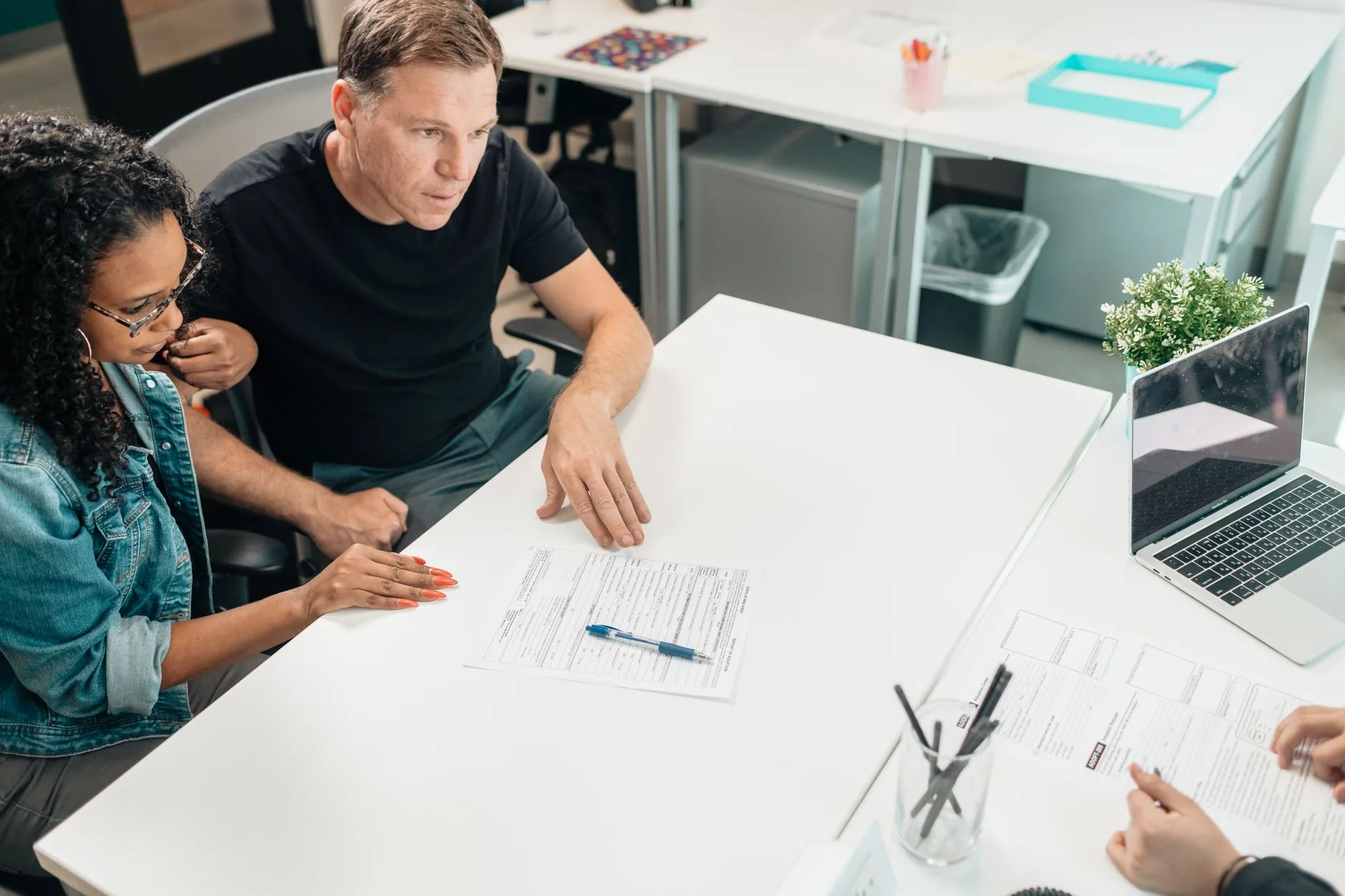 A couple reviewing a life insurance policy with an advisor at a desk