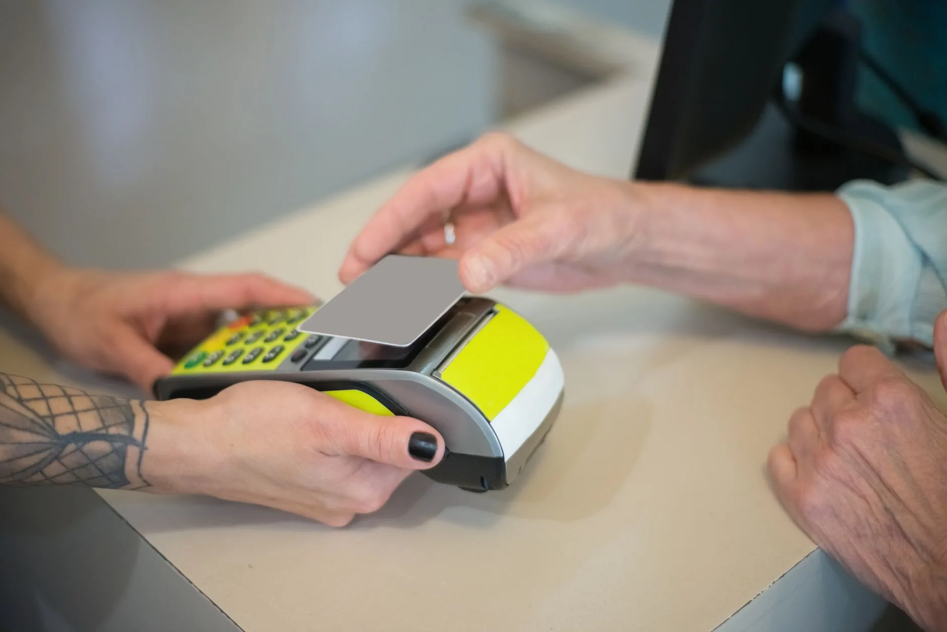 An older adult paying at a pharmacy checkout